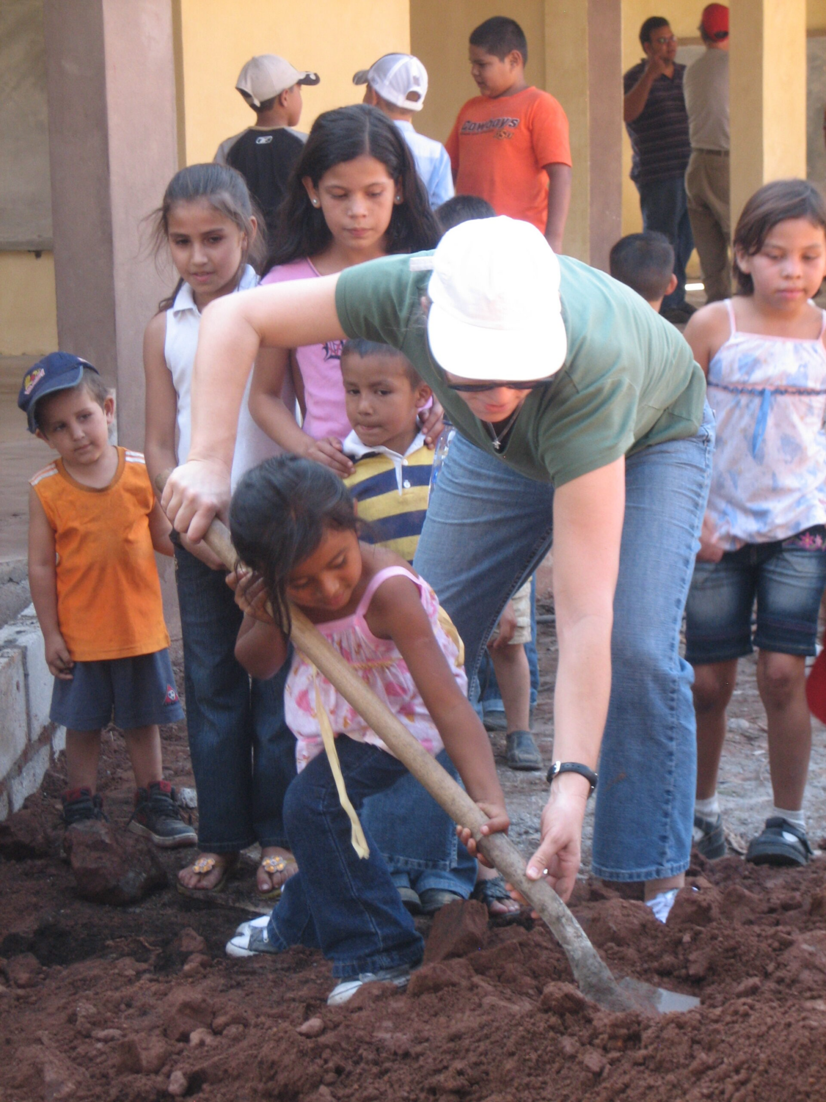 Child and adult digging together outdoors